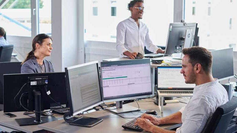Les employés de bureau vérifient leur gestion des temps de travail et leurs demandes de congé sur leur PC dans le logiciel prime WebTime.